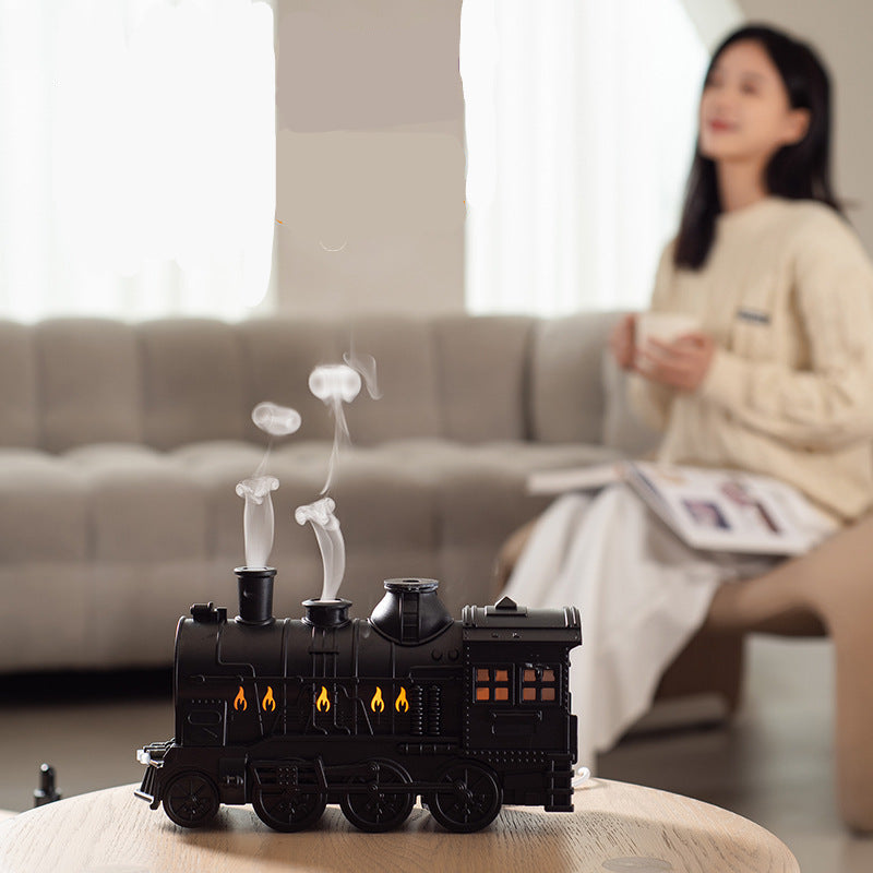 Retro-style small train aromatherapy humidifier in train black with remote control, featuring a large fog spray, dual mist outlets, and a square desktop design