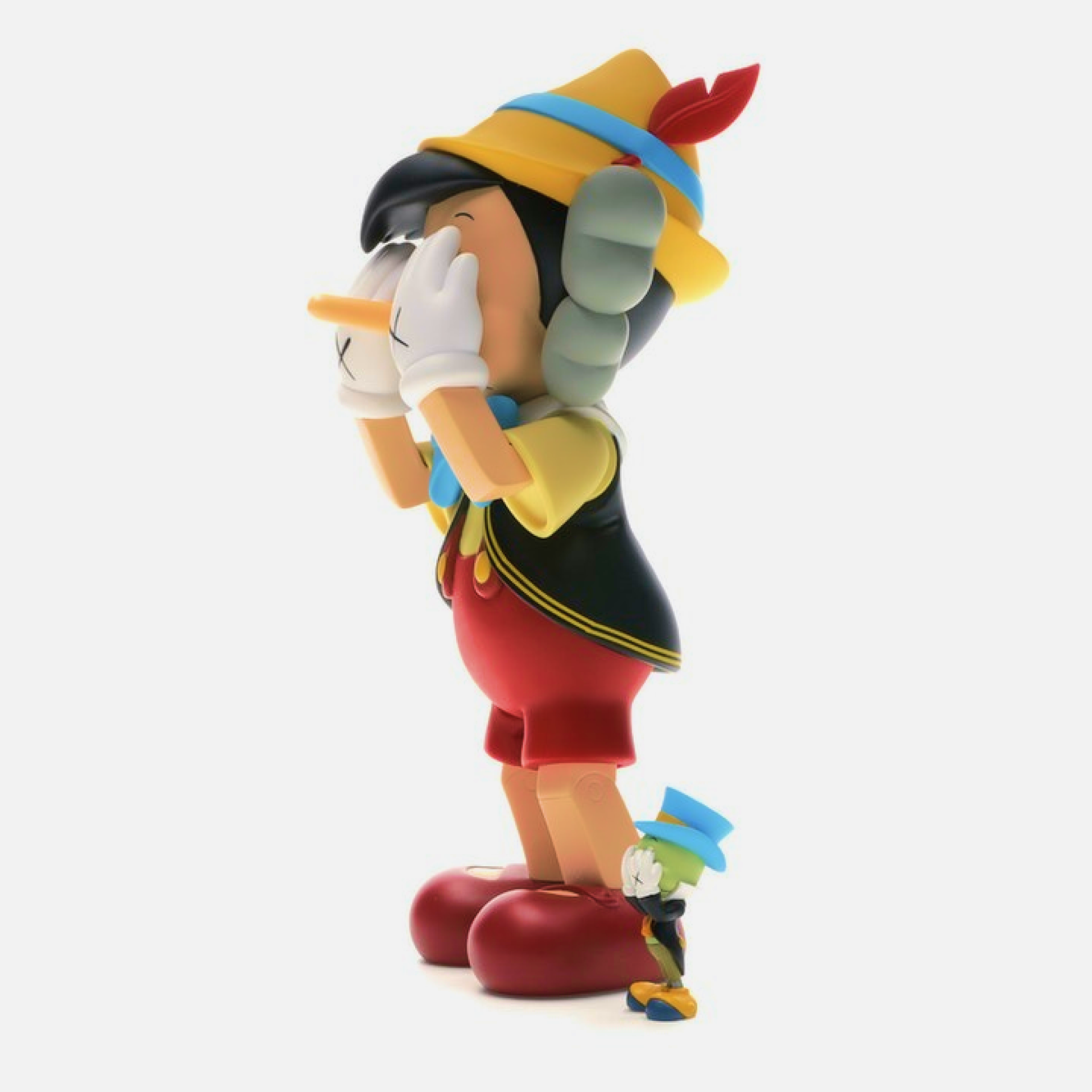 KAWS collectible cast vinyl figure featuring Pinocchio and Jiminy Cricket, limited edition from 2010, measuring 26×12.7×11.4 cm.