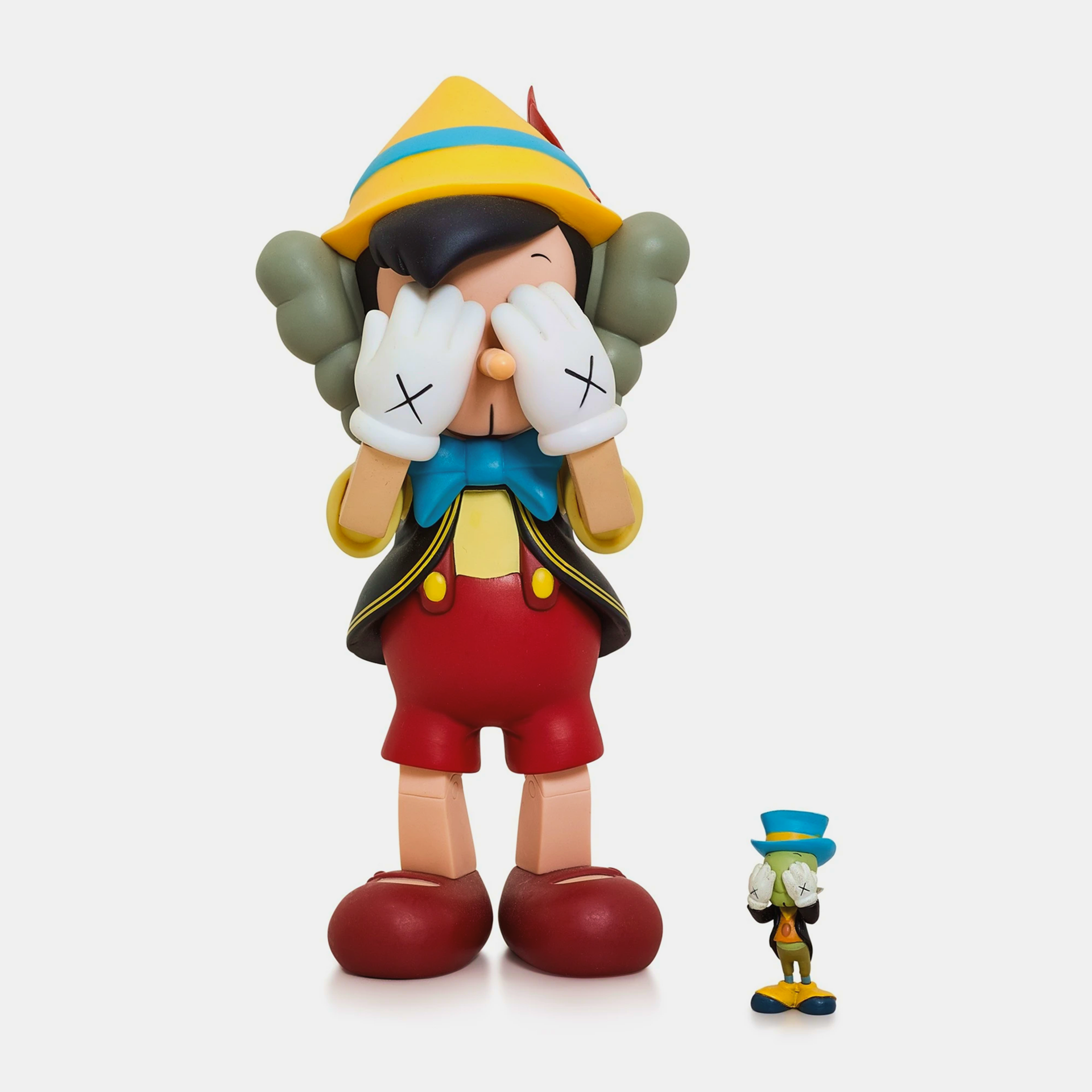 KAWS collectible cast vinyl figure featuring Pinocchio and Jiminy Cricket, limited edition from 2010, measuring 26×12.7×11.4 cm.